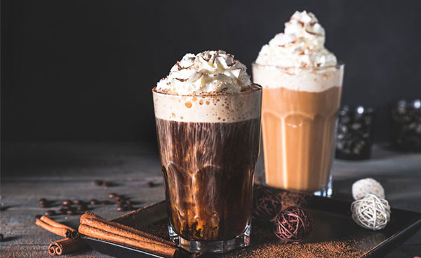 Holländischer Kaffee Advocat oder belgischer Diplomatenkaffee zwei Gläser mit unterschiedlich dunklem Kaffee, Likör, Sahnehaube